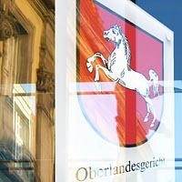 Foto einer Scheibe mit dahinterliegendem Wappen von Niedersachsen und Schriftzug Oberlandesgericht