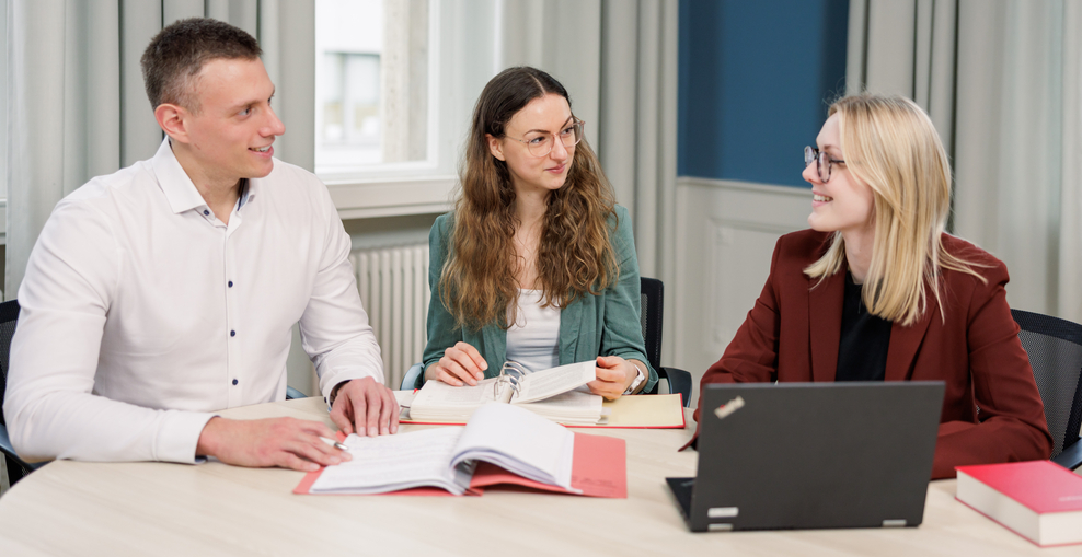 Kolleginnen und Kollegen sitzend und im Gespräch an einem runden Tisch